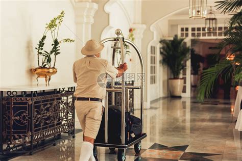 行李员推行李车将行李送到走廊酒店高清图片下载-正版图片503711564-摄图网