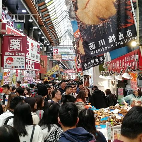 当地市场摊位上持新鲜海食品的年轻女在冰上买鱿高清图片下载-正版图片507437723-摄图网