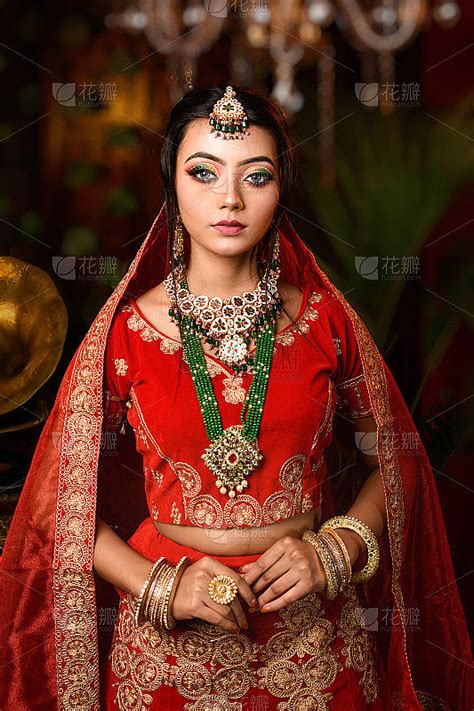 华丽的年轻印度新娘在豪华的新娘服装化妆和沉重的珠宝与经典的室内工作室照明。婚礼生活方式与时尚