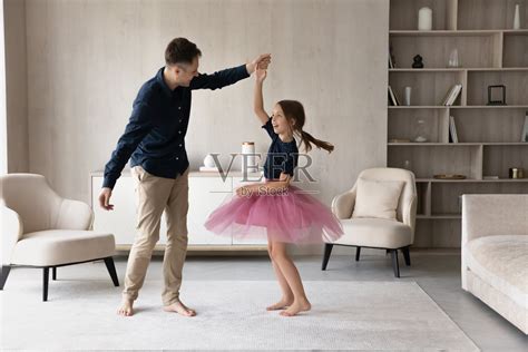 有爱的白人父亲牵着女儿的手，在家跳舞照片摄影图片_ID:415365641-Veer图库
