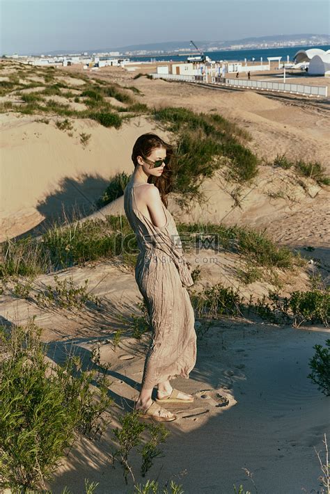 一个穿着长裙的苗条女人独自沿着荒凉的海滩散步高清摄影大图-千库网