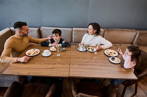 快乐的白人家庭在一家餐馆一起吃午饭。高清摄影大图-千库网