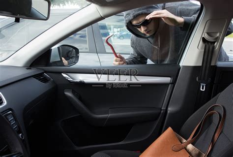 小偷正在寻找留在车里无人看管的贵重物品照片摄影图片_ID:132486203-Veer图库