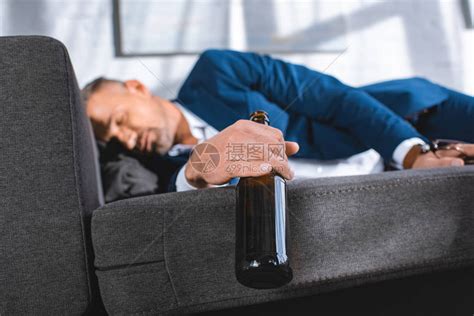 醉酒商人在沙发上睡觉时瓶子高清图片下载-正版图片502581640-摄图网