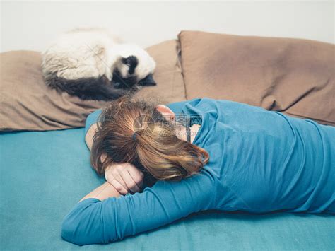 个轻的女人睡张床上,旁边只猫高清图片下载-正版图片300625163-摄图网