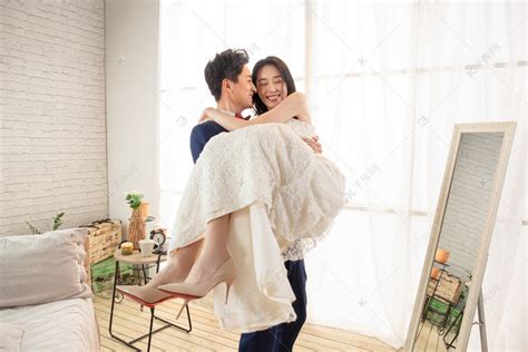 卧室里幸福的丈夫把妻子抱起来高清摄影大图-千库网