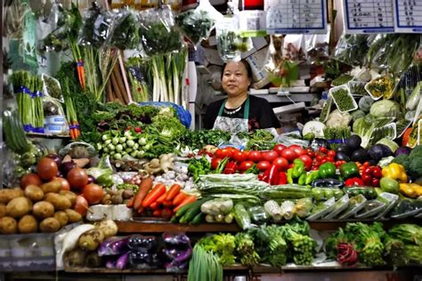 在市场上买蔬菜的年轻妇女在高清图片下载-正版图片503504557-摄图网