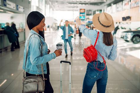 两名携带病例的女游客在机场与一位朋友见面高清图片下载-正版图片505964813-摄图网