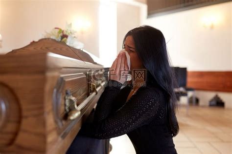 人与哀悼的概念-在教堂的葬礼上带着棺材哭泣的女人。高清摄影大图-千库网