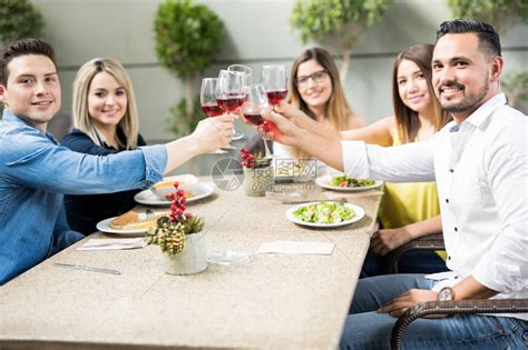 一群英俊的西班牙裔年轻成年人举起酒杯在餐厅敬酒高清图片下载-正版图片504984744-摄图网