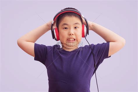 身戴耳机的亚洲男孩听音乐发疯尖叫惊兴奋孤立高清图片下载-正版图片503662189-摄图网