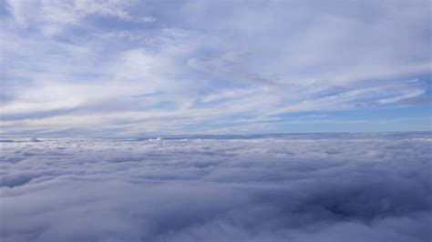 在茫茫的云海之上是湛蓝的天空阳光直射而下把一朵朵云彩照的通透明亮自然风景素材设计