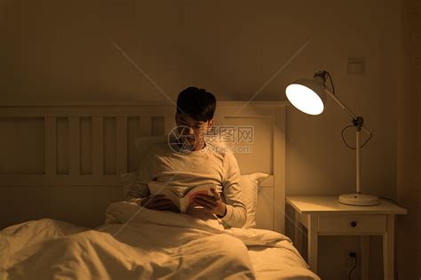 晚上坐在床头看书的年轻男性高清图片下载-正版图片500701276-摄图网