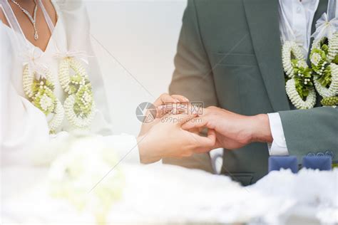 新娘在郎的婚礼那天在新郎的左手上戴结婚戒指高清图片下载-正版图片305843341-摄图网
