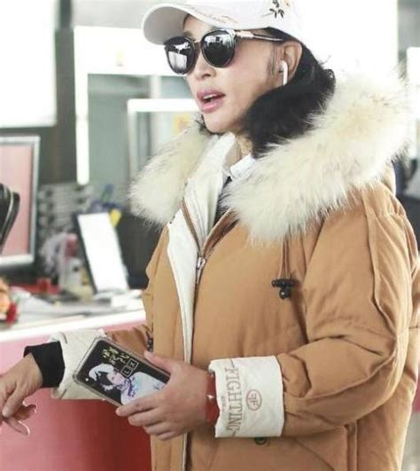 63岁刘晓庆现身机场，穿着打扮时尚显年轻，但她的年龄被手出卖