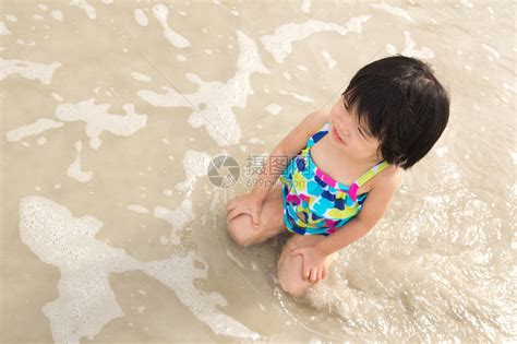 小女孩在沙滩上享受海浪高清图片下载-正版图片503578716-摄图网