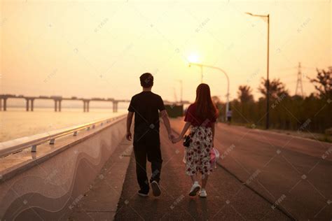 傍晚江边散步的情侣摄影图高清摄影大图-千库网