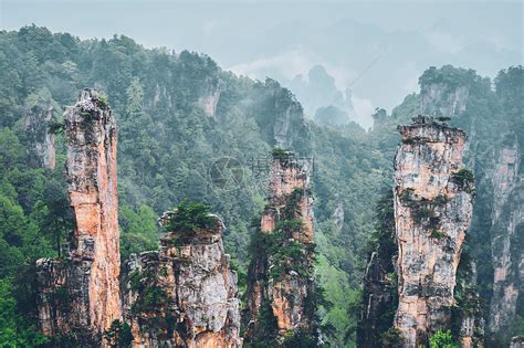 中国著名旅游胜地-中国湖南武陵源雾云中的张家界石柱悬崖山。山峦峡谷高清摄影大图-千库网