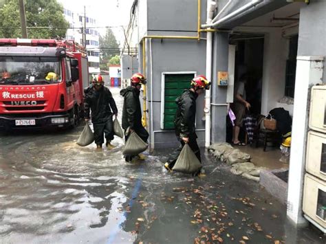 金山张堰镇一居民新村积水30厘米，消防员开水泵铺沙袋抢险