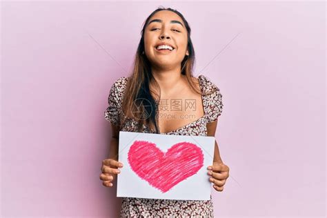 年轻的拉丁女人拿着心画微笑高清图片下载-正版图片503677310-摄图网