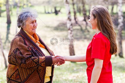 老妇人与年轻的看护人握手高清图片下载-正版图片507397034-摄图网