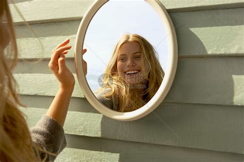 站在镜子前的年轻女子高清图片下载-正版图片501525144-摄图网