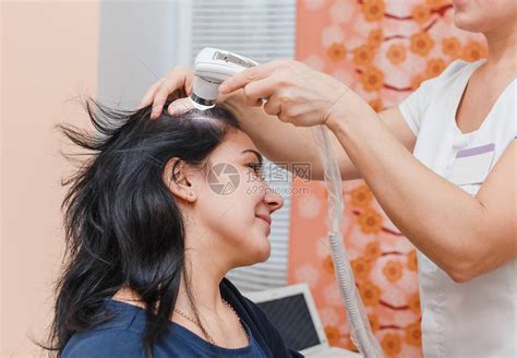在美容诊所对女患者的头皮和毛囊进行毛发学和皮肤病学检查高清图片下载-正版图片503623628-摄图网