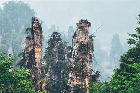 中国著名旅游胜地-中国湖南武陵源雾云中的张家界石柱悬崖山。高清摄影大图-千库网
