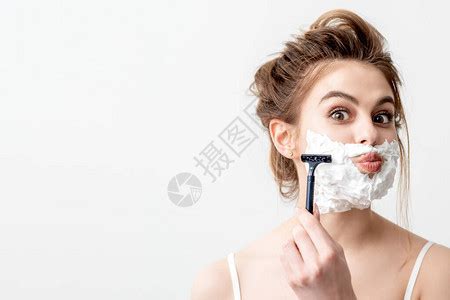 美丽的年轻caucasian女人用剃刀刮脸的白色背景高清图片下载-正版图片506639942-摄图网