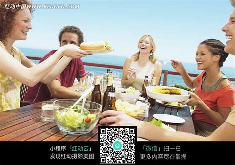 甲板木质长桌上喝酒聚餐的年轻人们图片免费下载_红动中国