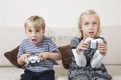 有小玩意的两个孩子姐妹和兄弟在家上网或在智能手机和数字平板电脑上玩在线游戏现代通信和小高清图片下载-正版图片502907333-摄图网