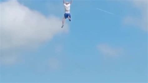 惊险！万宁一男子放巨型风筝 瞬间被风筝线带飞悬挂在半空中_新浪新闻