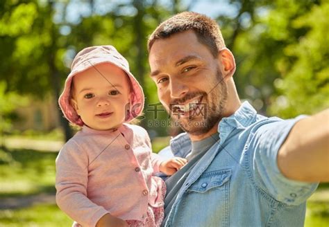家庭、父亲身份和人的概念-快乐的父亲在夏日公园与小女儿自拍。高清摄影大图-千库网