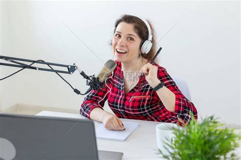 电台主持人概念作为电台主持人的女坐在工作室的白色背景高清图片下载-正版图片506190088-摄图网