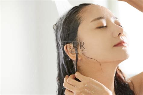 一个年轻的亚洲女人在浴室里洗头照片摄影图片_ID:403368605-Veer图库