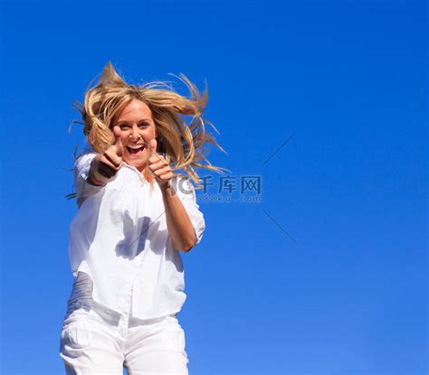 一个容光焕发的女人在户外空中跳跃的肖像高清摄影大图-千库网