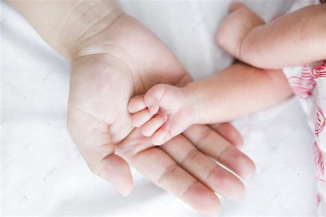 婴儿手势母婴新生大手拉小手手势摄影图配图高清摄影大图-千库网
