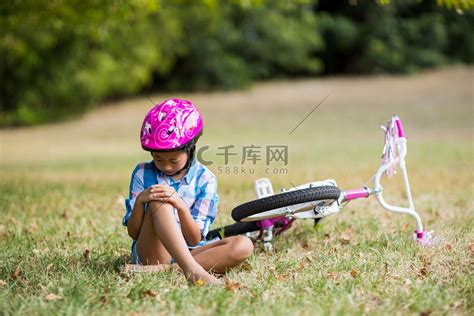 年轻女孩从自行车上摔下来受伤高清摄影大图-千库网