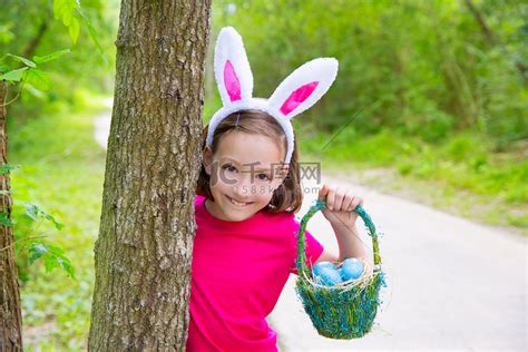复活节女孩带着鸡蛋篮子和滑稽的兔子脸高清摄影大图-千库网