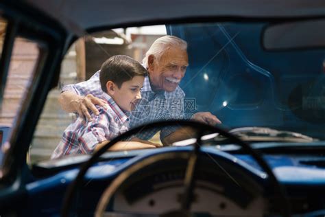 家庭和代沟老爷和孙子在一起这位老人展示了一辆从60年代到十几岁的孩子的老爷车的引擎他们笑得很开心高清图片下载-正版图片502704161-摄图网