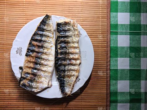 将切成薄片的鲭鱼与生菜，番茄和柠檬放在一个盘子里作为背景。切片鲭鱼与蔬菜在盘子上俯瞰。海鲜