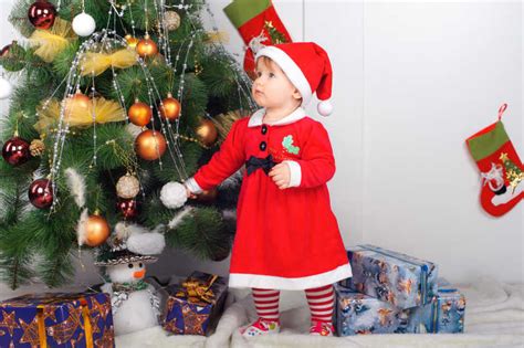 圣诞节图片-可爱的圣诞装扮的小女孩在圣诞树下素材-高清图片-摄影照片-寻图免费打包下载