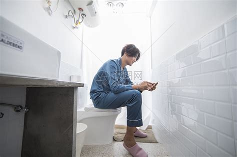 男生在厕所里看手机高清图片下载-正版图片500683697-摄图网