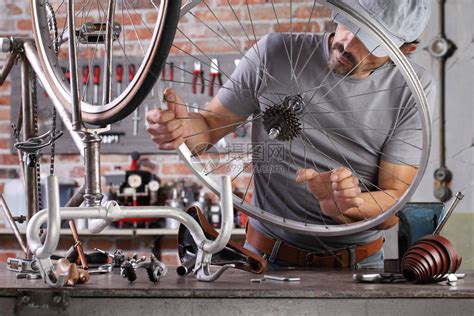 男人用工具修车厂工作台的旧自行车高清图片下载-正版图片506501533-摄图网