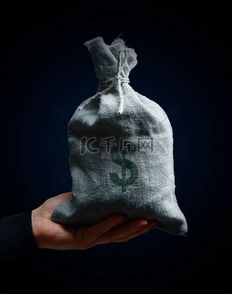 一只女手拿着一个满是麻袋的袋子，上面有美元符号，财富概念，盈利的生意高清摄影大图-千库网