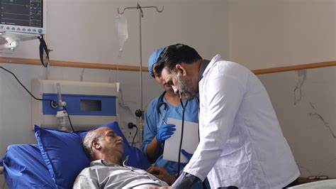 医生和护士一起检查躺在病床上的病人视频素材_ID:VCG42N1402635038-VCG.COM