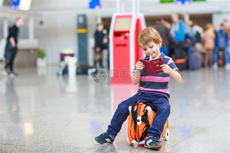 美丽的金发男孩在机场室内有好玩的手提箱高清图片下载-正版图片503581237-摄图网