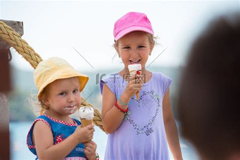 在海边吃冰淇淋的小女孩高清摄影大图-千库网