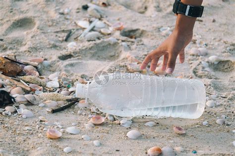 手臂特写孩子们正在捡拾留在海滩上的塑料瓶高清图片下载-正版图片506079506-摄图网