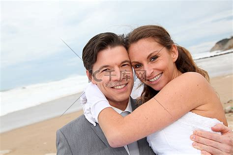 在海滩上，新郎把新娘抱在怀里人物特写合影高清摄影大图-千库网